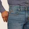 Close-up of blue jeans with a plaid shirt on a beige background
