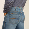 Person wearing blue jeans and a checkered shirt on a beige background