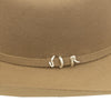 Close-up of a brown hat with a decorative band featuring three silver loops on a white background.