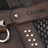 Close-up of a brown leather product with 'Cuadra' branding and silver studs.