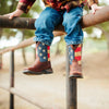 Child wearing American flag-patterned boots on a playground.