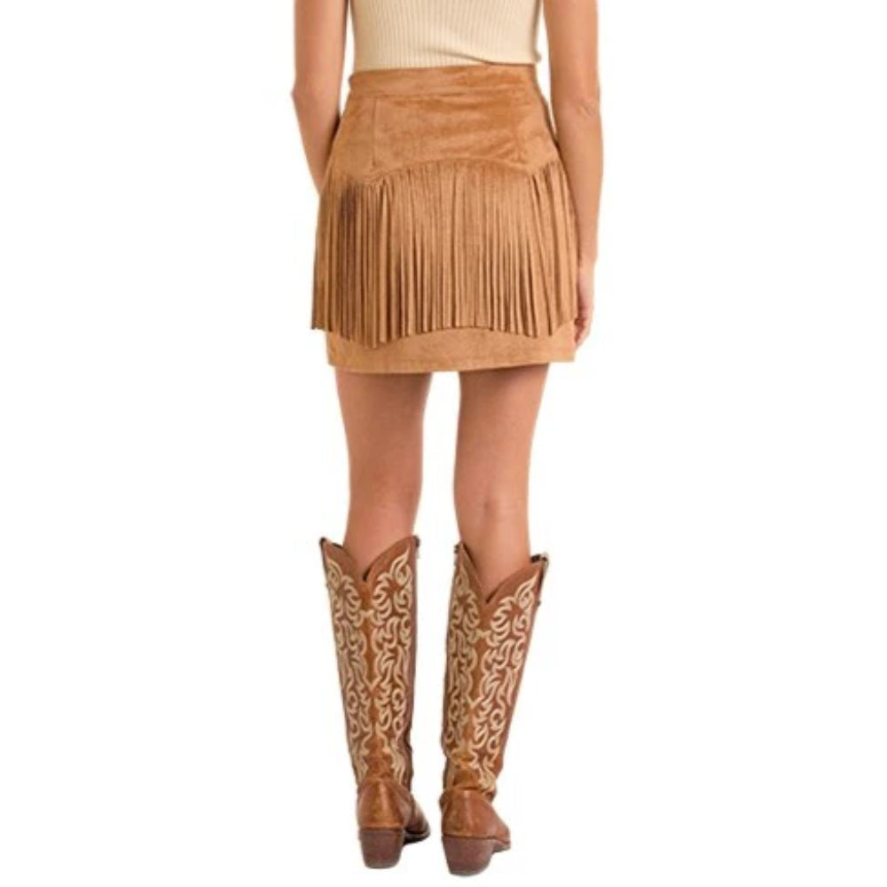 Person wearing a brown suede skirt and cowboy boots on a white background