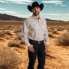 Man wearing a cowboy hat and shirt standing in a desert landscape