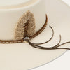 Close-up of a beige hat with a feather detail on a white background