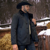 Man wearing a dark coat and cowboy hat standing in a snowy rural setting.