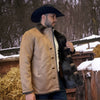 Man wearing a tan jacket with fur lining and a black cowboy hat in a snowy outdoor setting.