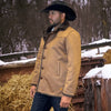 Man wearing a tan jacket and cowboy hat standing in a snowy outdoor setting with hay and wooden structures.