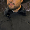 Close-up of a person wearing a black coat with a fur-lined hood.