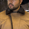 Close-up of a person wearing a brown leather jacket with a dark collar.