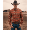 Man wearing a patterned shirt, jeans, and a cowboy hat in an outdoor setting.