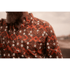Person wearing a patterned shirt with a blurred background