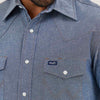 Close-up of a blue denim shirt with Wrangler logo on pocket